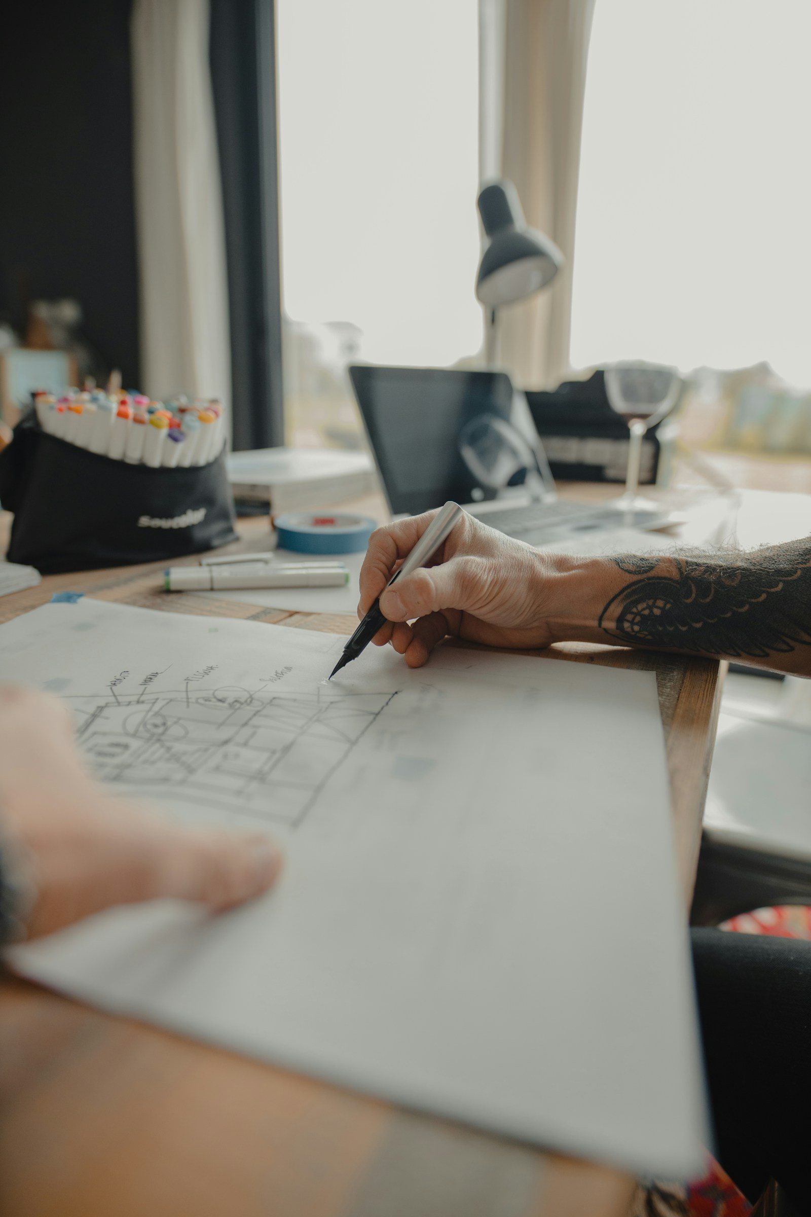 Mains du designer dessinant un plan d’architecture